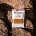 Packaged bush curry mix on a rocky surface